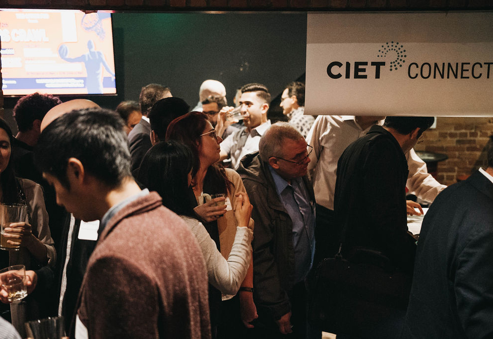 Professionals speaking to each other in front of a CIET Connect sign