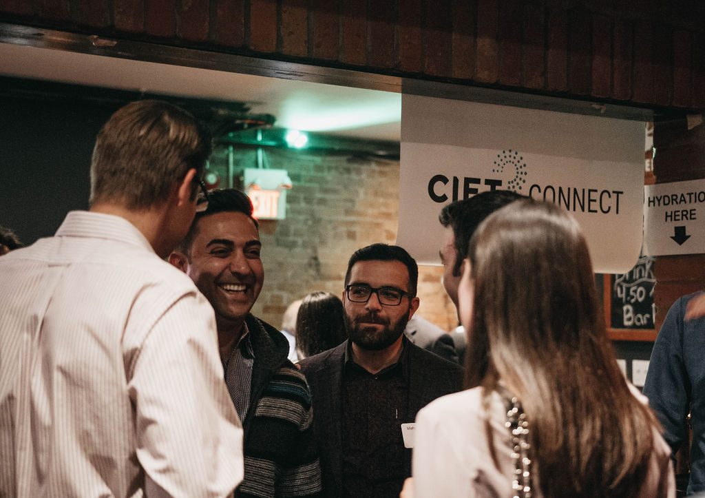 Professionals speaking to each other in front of a CIET Connect sign